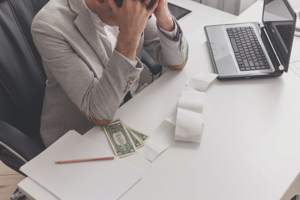 Young man frustrated at his house by debt